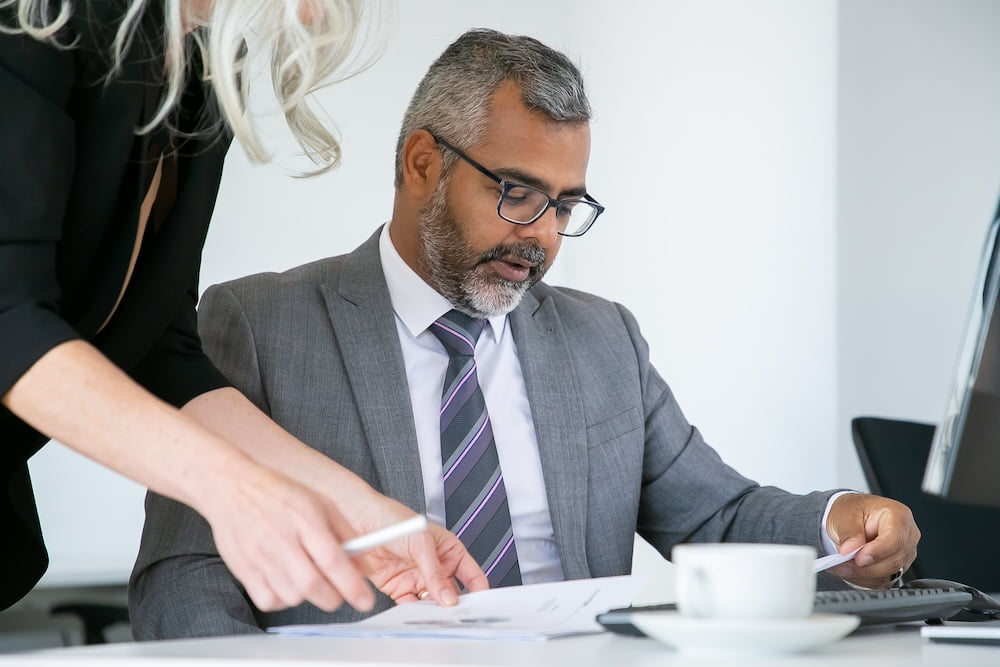 Focused boss analyzing managers report